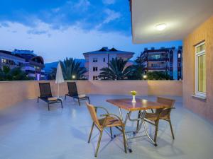 a patio with a table and chairs on a balcony at May Flower Apart Hotel in Alanya