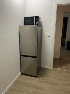 einen Kühlschrank mit einer Mikrowelle darüber in der Unterkunft Appartement 1 in Stuttgart