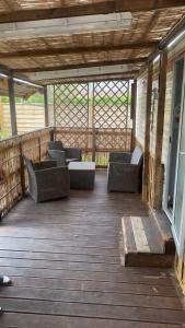 a porch with wicker chairs on a wooden deck at L'Ardres de paix in Ardres