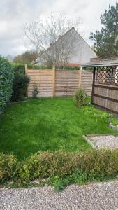 a backyard with a fence and green grass at L'Ardres de paix in Ardres