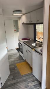 a small kitchen with white cabinets and a sink at L'Ardres de paix in Ardres