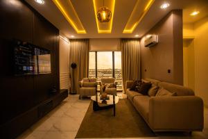 Una sala de estar con un sofá y sillas y una mesa. en Luxuryliveinn, en Mama