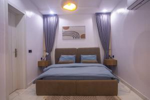 Un dormitorio con una cama con sábanas azules y almohadas azules. en Luxuryliveinn, en Mama 5 fotos más