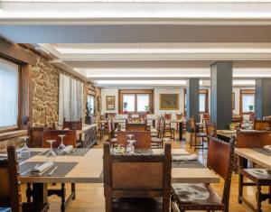 a dining room with tables and chairs and windows at Hotel Rural Izar Ondo in Arbizu +50 photos