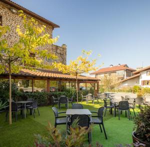 a patio with tables and chairs in front of a building at Hotel Rural Izar Ondo in Arbizu