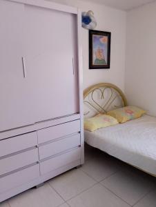 a bedroom with a bed next to a dresser and a bed sidx sidx sidx at Lar caprichoso in Aracaju
