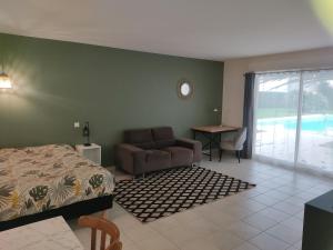 a bedroom with a bed and a couch and a table at Médis Royan Saujon in Médis