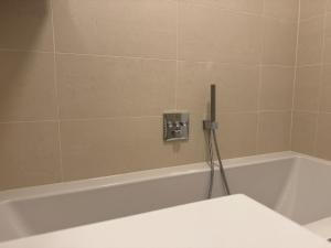 La salle de bains est pourvue d'une baignoire blanche avec une prise. dans l'établissement train station, 2BR, Danube, Kahlenberg, Historic - FHG 20, à Vienne