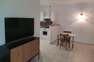 a kitchen with a television and a table and chairs at Médis Royan Saujon in Médis