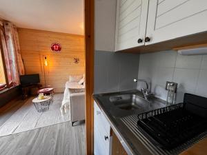 a kitchen with a sink and a living room at Charmant studio Morzine Centre in Morzine