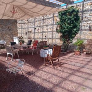 an outdoor patio with tables and chairs and an umbrella at NEU! Ferienwohnung Storchennest OG in Pömmelte