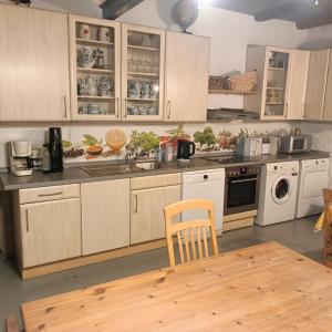 a kitchen with white cabinets and a wooden table at NEU! Ferienwohnung Storchennest OG in Pömmelte