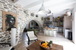 a kitchen and living room with a stone wall at Bardelours 1 Charming house with swimming pool in the heart of the Pic Sa in Saint-Bauzille-de-Montmel
