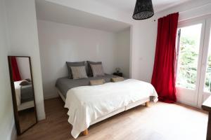 a bedroom with a bed and a mirror and a window at Bardelours 1 Charming house with swimming pool in the heart of the Pic Sa in Saint-Bauzille-de-Montmel