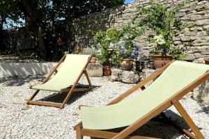 two folding chairs in a garden with flowers at Bardelours 2 Charming apartment with terrace in the heart of the villag in Saint-Bauzille-de-Montmel