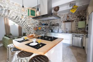 een keuken met een tafel met stoelen en een fornuis bij Bardelours 4 - Charming villa with private pool - 6 bedrooms in Saint-Bauzille-de-Montmel +45 foto's