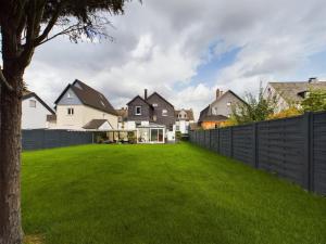 a house with a fence and a green yard at Villa am Staderhof in Leichlingen
