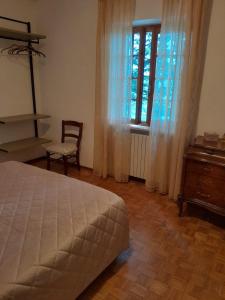 a bedroom with a bed and a chair and a window at Barino Pietragavina 