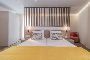 een slaapkamer met een groot bed met een gele deken bij Galega Villas in Milharado