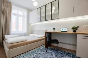 a bedroom with a bed and a desk and a chair at K26UrbanNest in Wrocław