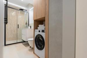 a bathroom with a washing machine and a toilet at K26UrbanNest in Wrocław