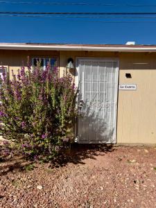 a house with a garage with purple flowers in front of it at Las Casita-Cozy Apartment near Airport, Downtown, UTEP, Fort Bliss in El Paso