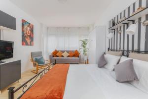 ein Schlafzimmer mit einem großen weißen Bett und einer Couch in der Unterkunft Lakeside Hideaway - Lakefront & Central in Lecco