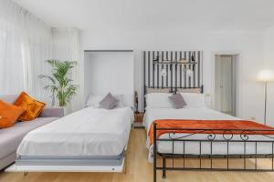 ein Schlafzimmer mit zwei Betten und einer Couch in der Unterkunft Lakeside Hideaway - Lakefront & Central in Lecco