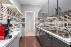 eine große Küche mit Edelstahlgeräten und roten Fliesen in der Unterkunft Lakeside Hideaway - Lakefront & Central in Lecco + 28 Fotos