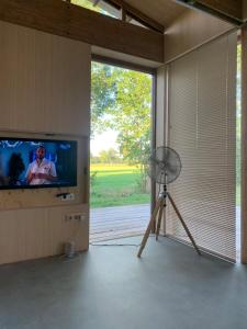 une chambre avec une télévision à écran plat et un ventilateur dans l'établissement Bamboo House, à Boyl