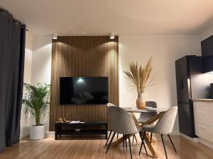 sala de estar con mesa con sillas y TV en Bryza Morska, en Świnoujście