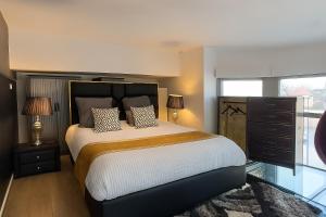 a bedroom with a large bed with two pillows at GlamappartSpa Prestige New-York expérience in Reims