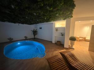 Una gran piscina azul en una habitación con dos sillas en Olbia City Hotel & Spa, en Olbia