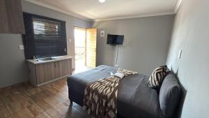 a bedroom with a bed and a sink at Gnostes Lodge Vosloorus in Vosloorus