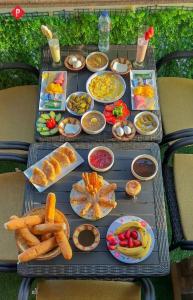 una mesa con un montón de diferentes tipos de comida en Hur Pyramids Inn, an Mabit Stays, en El Cairo