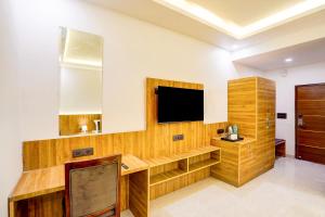 Habitación con TV y pared de madera. en Townhouse GRAND ADDRESS HOTEL AND BANQUET, en Ghaziabad