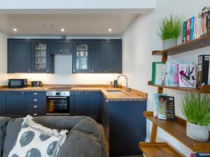 a kitchen with navy blue cabinets and a couch at Anchorage View in Dartmouth