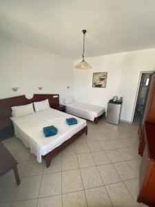 a bedroom with two beds in a room at Elpis Rooms in Mylopotas