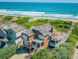Una vista aérea de una casa con el océano al fondo. en K0510 Sunday Drive - Oceanfront, Pool, Hot Tub, Fall Availability!, en Whalebone