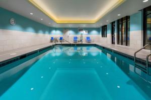 a swimming pool with blue chairs in a building at Holiday Inn Express Durango Downtown- Animas River in Durango