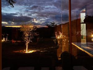 - Vistas nocturnas a un jardín con un árbol y luces en Recanto da Natureza, en Itabirito