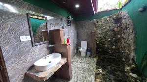 Un baño con lavabo y pared de piedra. en Sigiri Close-up View Guest, en Sigiriya