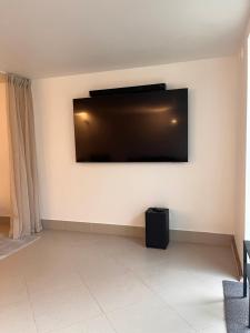 a living room with a flat screen tv on the wall at Woodstock IX, self check-in in Riga