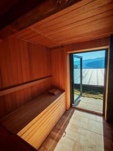 una sauna de madera con una gran ventana. en Moon Lake Bicaz - Casa Oia, en Buhalniţa