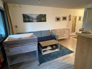 a living room with a couch and a crib at Ferienwohnung Sunnabichi in Wertach