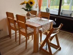 a dining room table with chairs and a vase of flowers on it at Ferienwohnung Sunnabichi in Wertach