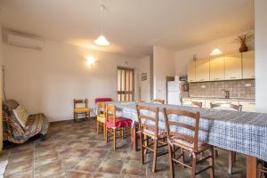 a kitchen and dining room with a long table and chairs at Veranda Vista Mare Isola Rossa in Isola Rossa