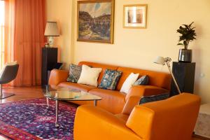 ウィーンにあるHerrlicher Ausblick über Wienのリビングルーム(オレンジカウチ、ガラステーブル付)