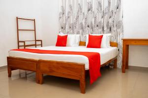 une chambre avec un lit avec des oreillers rouges et blancs dans l'établissement Altura Villa Galle, à Galle