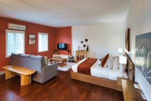 a bedroom with red walls and a bed and a couch at Condo Hôtel Magog Orford in Orford